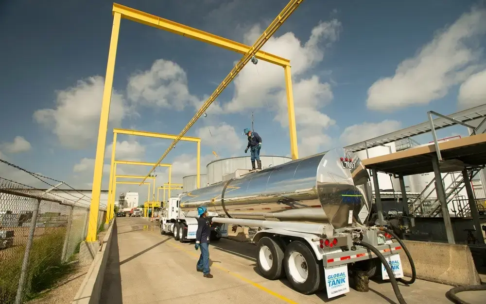 Tank truck drivers on top of trailer using life line system