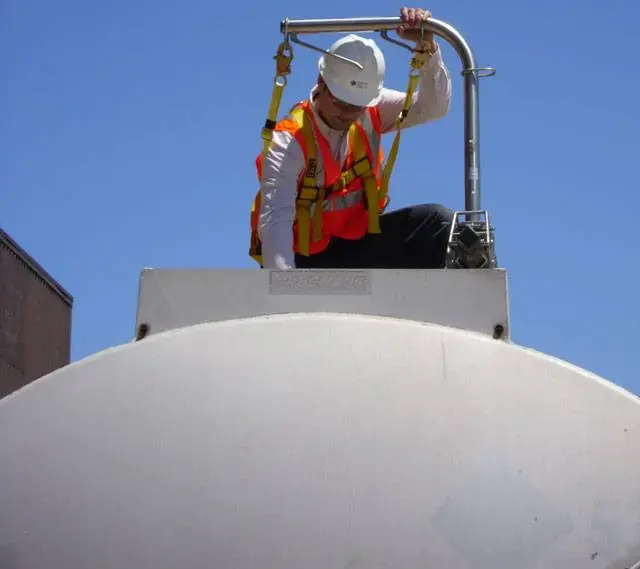 Tank truck operator inspecting trailer with SFTram fall protection system